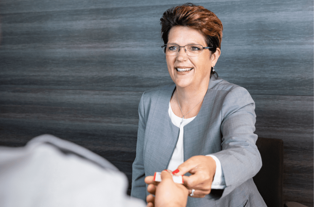 Medewerker receptie geeft parkeerkaart uit aan klant