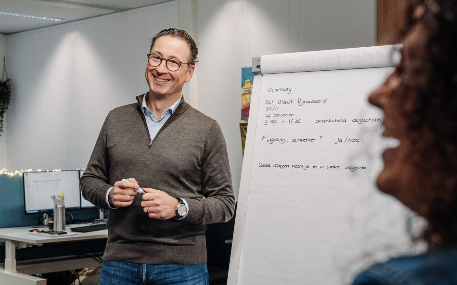 Man geeft presentatie aan collega bij flip-over tijdens zakelijke bijeenkomst