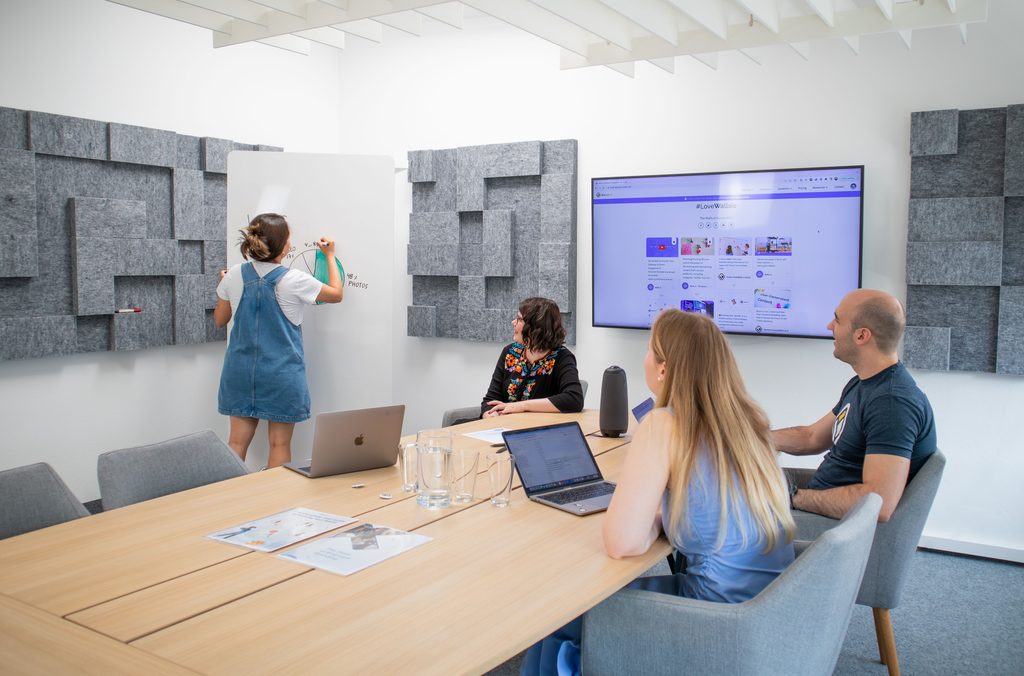 Mensen die aan het vergaderen zijn met laptops en whiteboard
